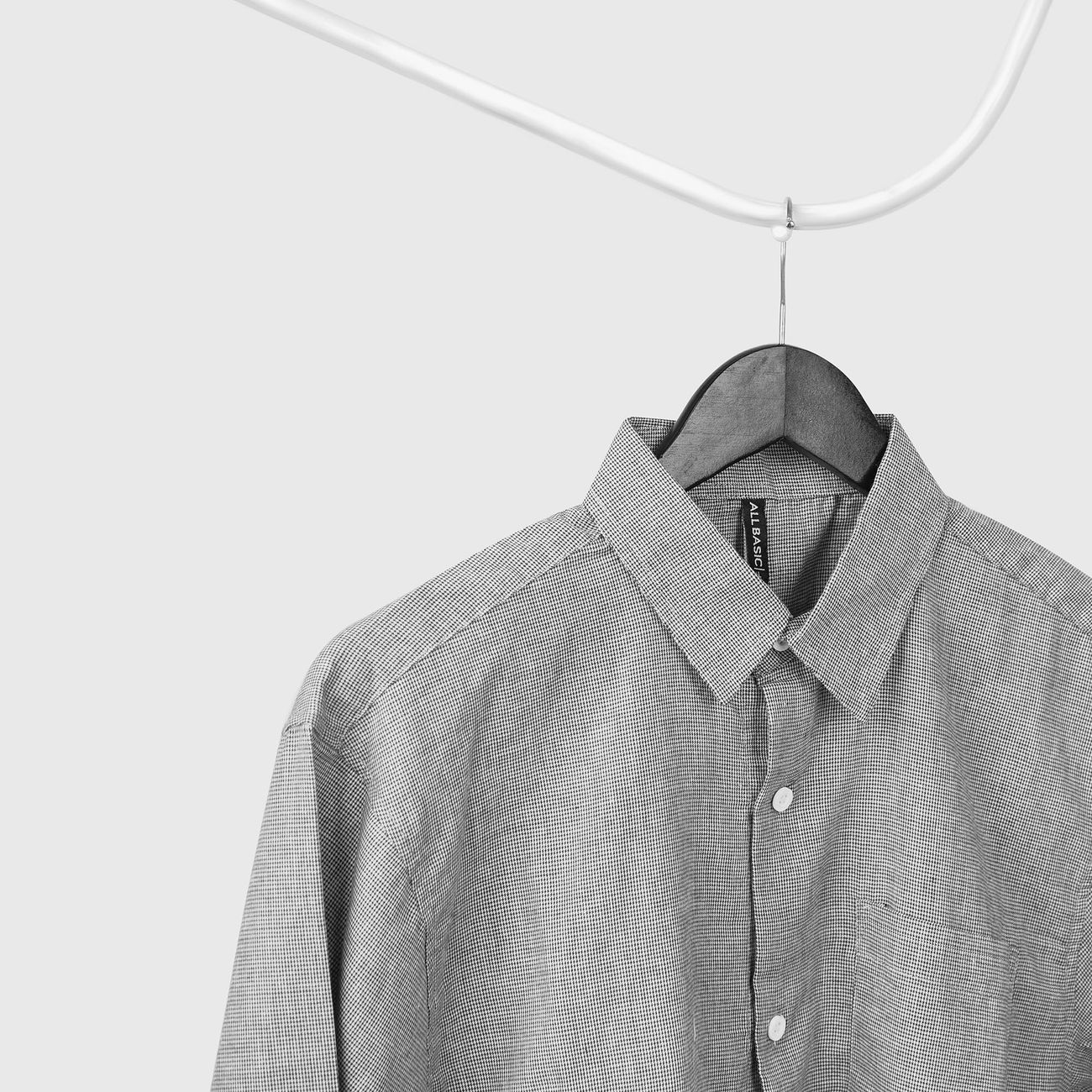 Sample: a grey shirt on a thin wire hanger against a white wall